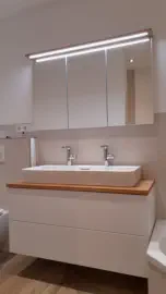 Weißer Waschtischunterschrank mit Abdeckung in Eiche, breitem Waschbecken und beleuchtetem Spiegelschrank