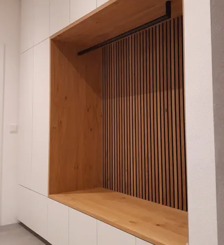 Weiße Einbaugarderobe nach Maß mit offener Eichennische, Lamellenrückwand und schwarzer Kleiderstange