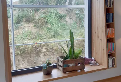 Tiefe Fensterbank in Eiche mit schmalem Bücherregal an der Seite