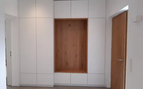 Grifflose weiße Flurschrankwand vom Boden bis zur Decke mit offener Nische in Eiche