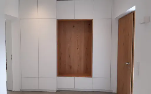 Grifflose weiße Flurschrankwand vom Boden bis zur Decke mit offener Nische in Eiche