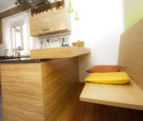 Am Küchenblock angesetzte Sitzbank mit Ablagebord in Holz