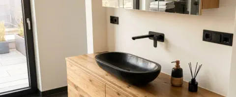 Waschtisch nach Maß in rustikaler Eiche mit schwarzem Aufsatzbecken und Spiegelschrank in Holz