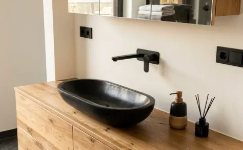 Waschtisch nach Maß in rustikaler Eiche mit schwarzem Aufsatzbecken und Spiegelschrank in Holz